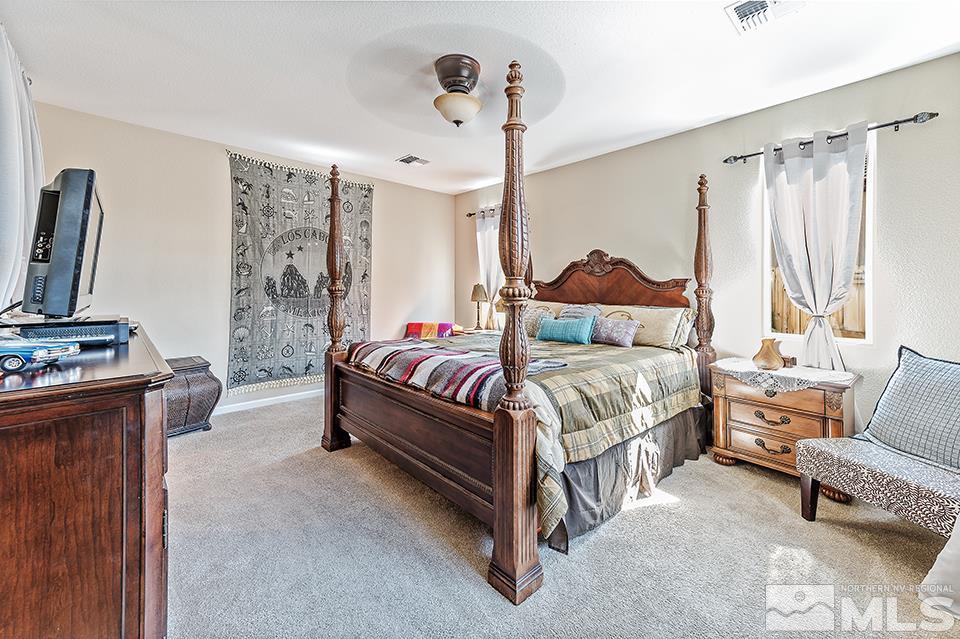 2220 Trakehner Lane Reno, NV 89521 - Photo 11 of 25 a bedroom with a bed and a chandelier