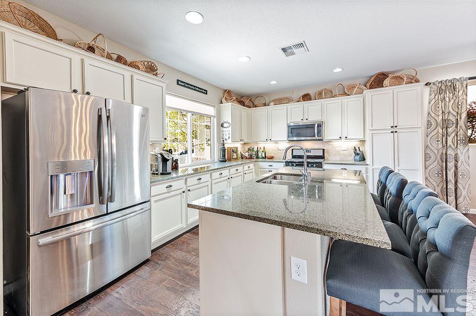 2220 Trakehner Lane Reno, NV 89521 - Photo 3 of 25 a kitchen with stainless steel appliances granite countertop a refrigerator a stove a sink and white cabinets