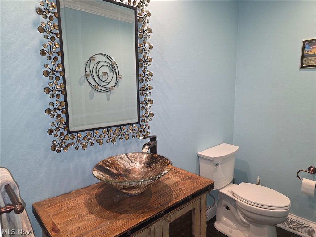 2868 Shade Road Akron, OH 44333 - Photo 10 of 49 Vanity with a glass vessel sink and dark bronze faucet, set against a light blue wall