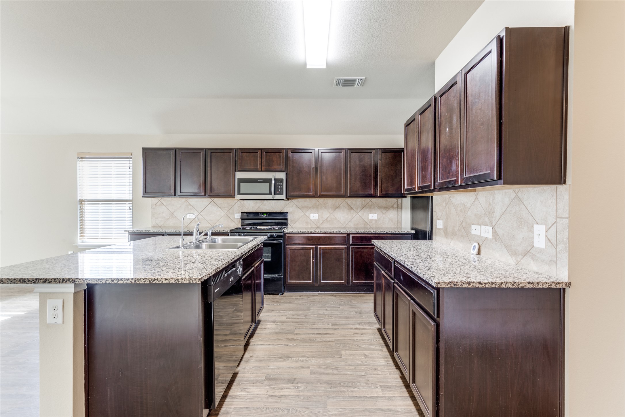 801 Silver Wing Drive Austin, TX 78725 - Photo 12 of 29 a kitchen with stainless steel appliances granite countertop a sink a stove and a refrigerator