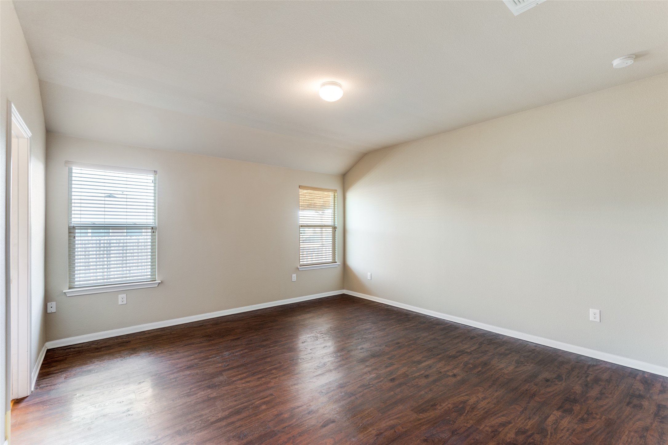 801 Silver Wing Drive Austin, TX 78725 - Photo 13 of 29 an empty room with wooden floor and windows