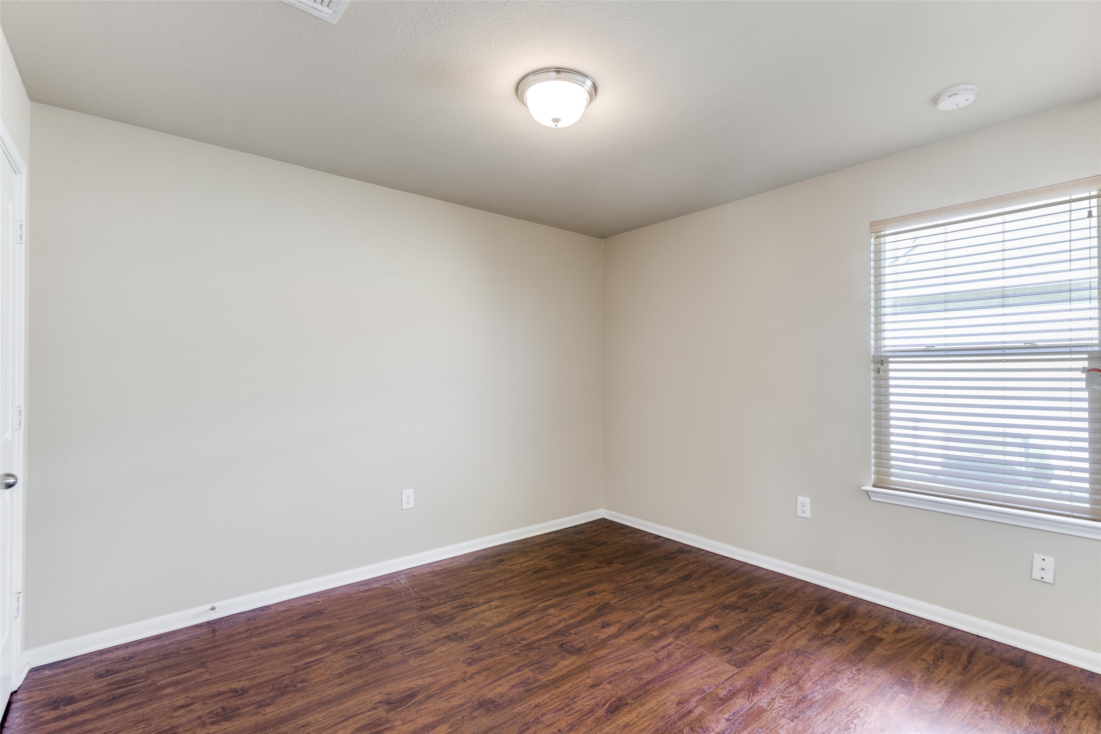 801 Silver Wing Drive Austin, TX 78725 - Photo 17 of 29 a view of an empty room with wooden floor and a window