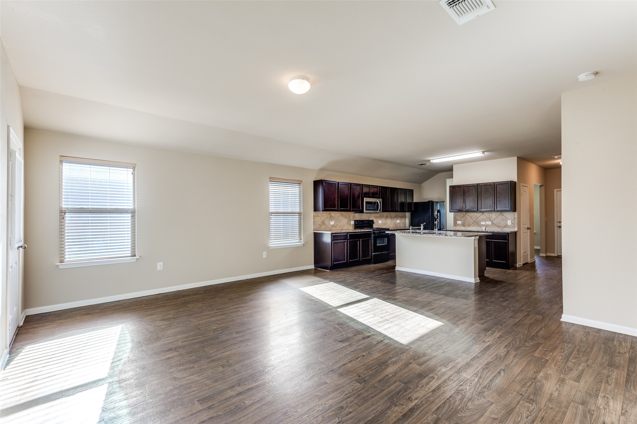 801 Silver Wing Drive Austin, TX 78725 - Photo 27 of 29 a kitchen with stainless steel appliances kitchen island wooden cabinets and granite counter tops