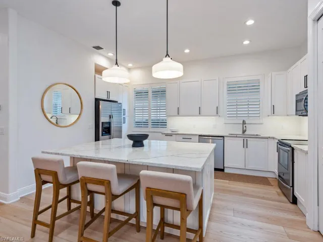 a kitchen with a dining table cabinets and appliances