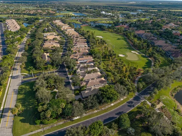 an aerial view of residential houses with outdoor space and trees