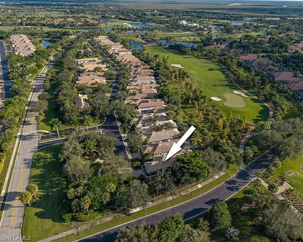 an aerial view of residential houses with outdoor space and trees