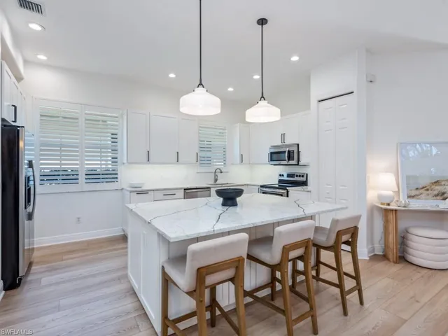 a kitchen with a dining table chairs sink and cabinets