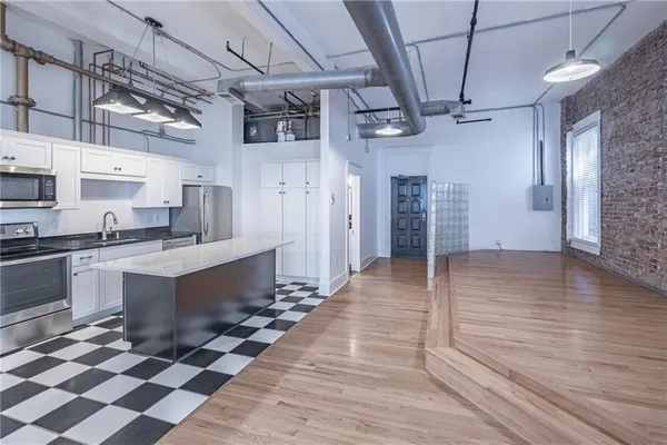 a kitchen with granite countertop white cabinets and black stainless steel appliances