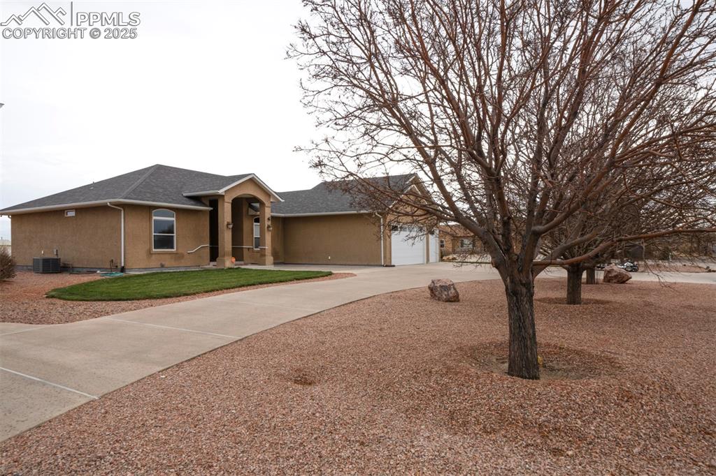 24484 Gale Road Pueblo, CO 81006 - Photo 2 of 43 a front view of a house with a dirt yard and a large tree