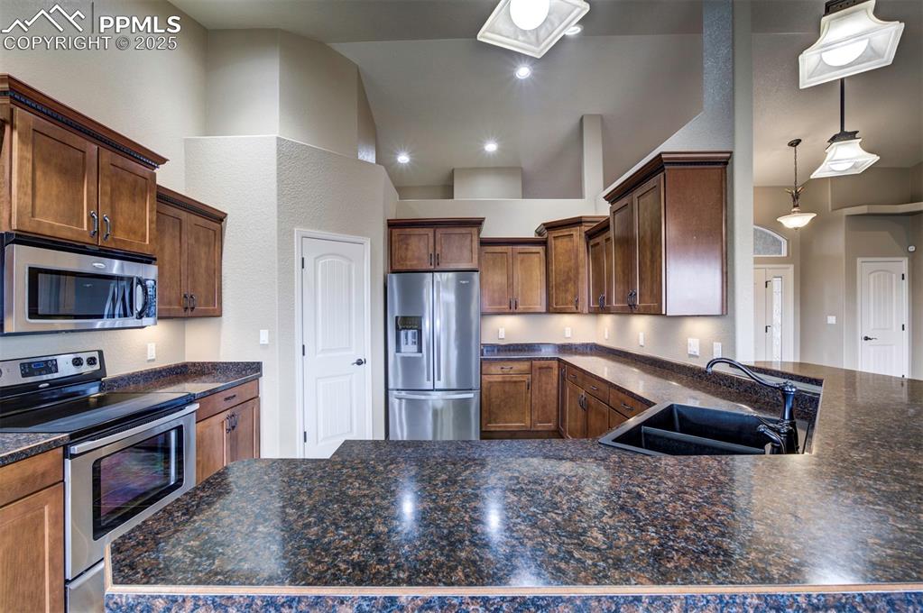 24484 Gale Road Pueblo, CO 81006 - Photo 21 of 43 a kitchen with granite countertop a stove a sink and a refrigerator