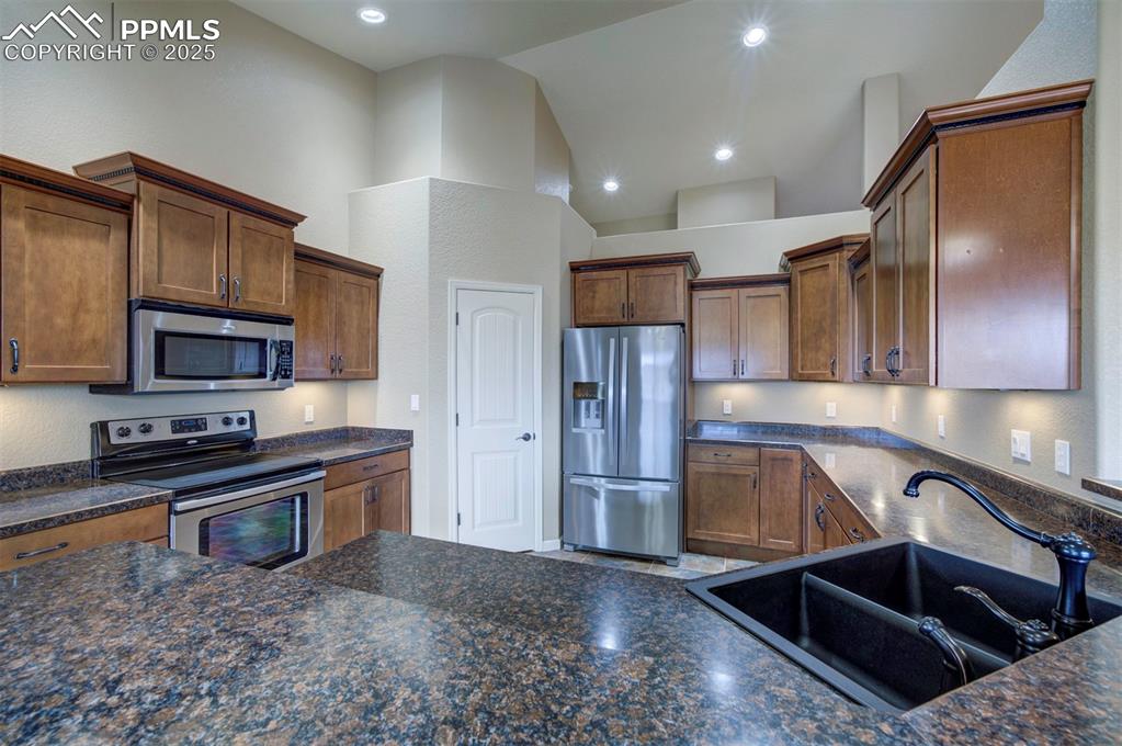24484 Gale Road Pueblo, CO 81006 - Photo 22 of 43 a kitchen with stainless steel appliances granite countertop a sink a stove and a refrigerator
