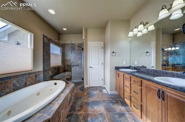 a spacious bathroom with a granite countertop tub sink shower and mirror
