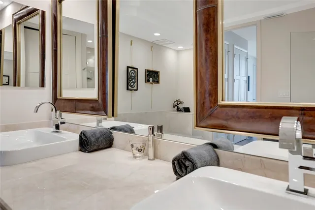 a bathroom with a tub double sink and mirror