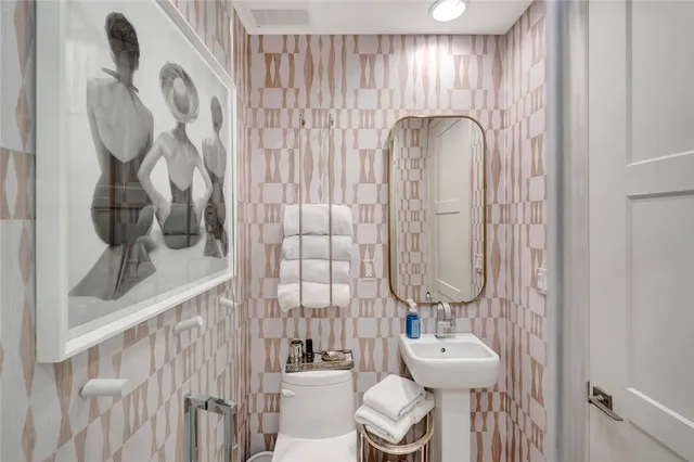 a bathroom with a sink vanity mirror and toilet