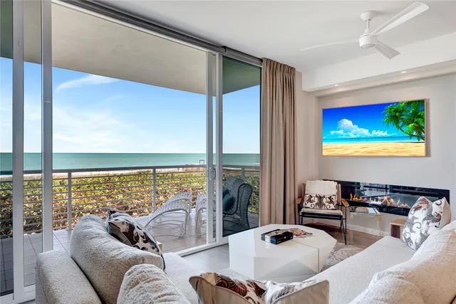 a living room with fireplace furniture and a large window
