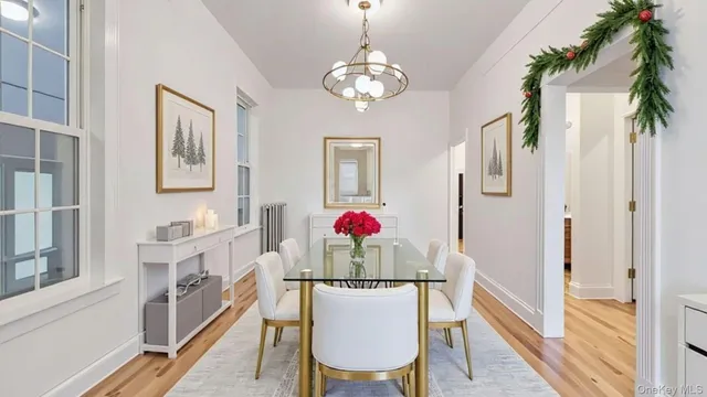 a view of a dining room with furniture a chandelier and wooden floor