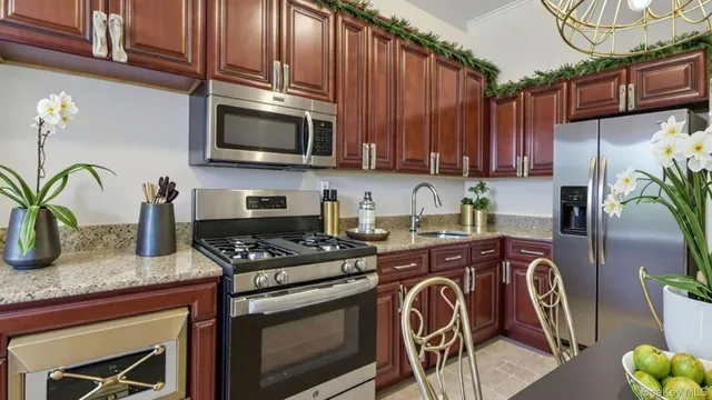 a kitchen with stainless steel appliances granite countertop a stove a sink and a microwave