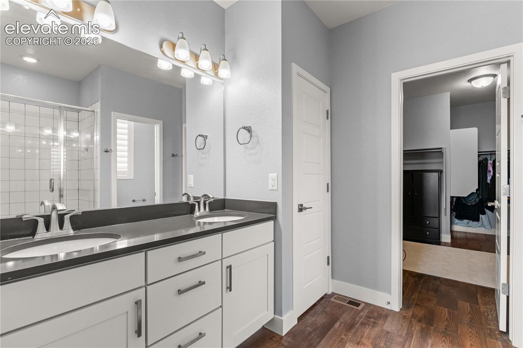 12781 Granite Ridge Drive Peyton, CO 80831 - Photo 17 of 41 Dual vanities, quartz countertops, and a huge walk in closet.