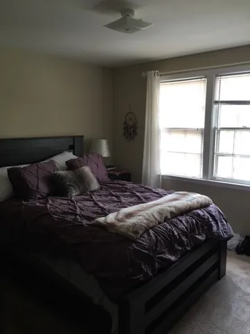 a bedroom with a bed and window