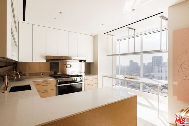 a kitchen with stainless steel appliances a stove a sink and a refrigerator with wooden floor