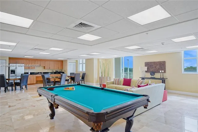 a room with pool table furniture and windows