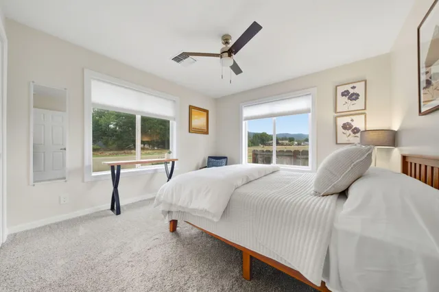 a bedroom with a bed and a large window