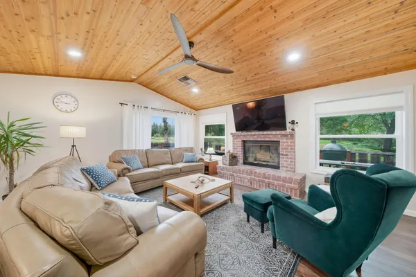 a living room with furniture a fireplace and a flat screen tv