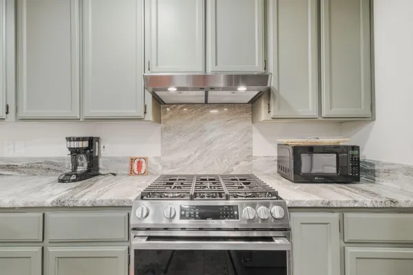 a stove top oven sitting inside of a kitchen