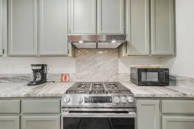 a stove top oven sitting inside of a kitchen
