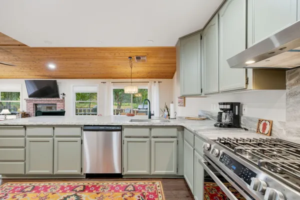 a kitchen with stainless steel appliances a stove a sink and a microwave