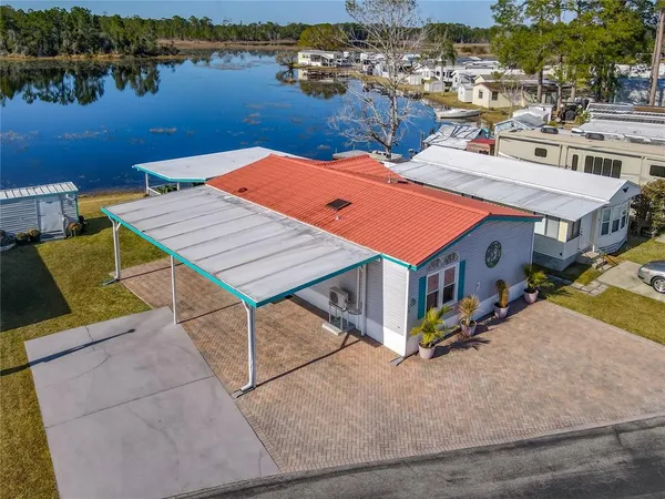 an aerial view of a house with outdoor space and lake view