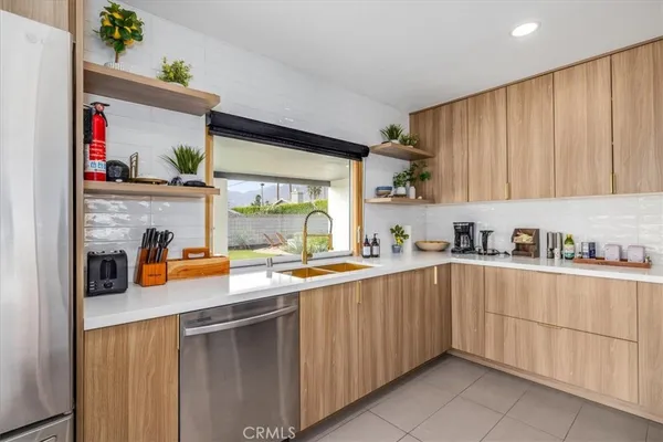a kitchen with stainless steel appliances a sink dishwasher and cabinets with wooden floor