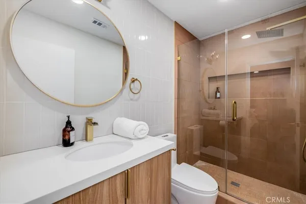 a bathroom with a sink a toilet and a mirror