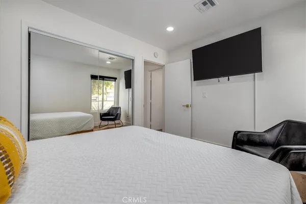 a bedroom with a bed and a flat screen tv