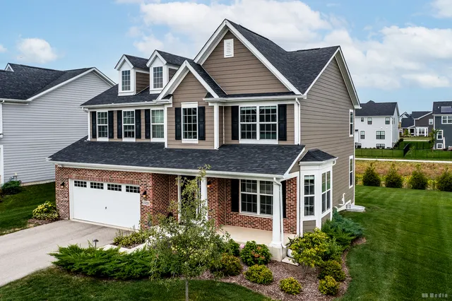 a front view of a house with a yard and trees