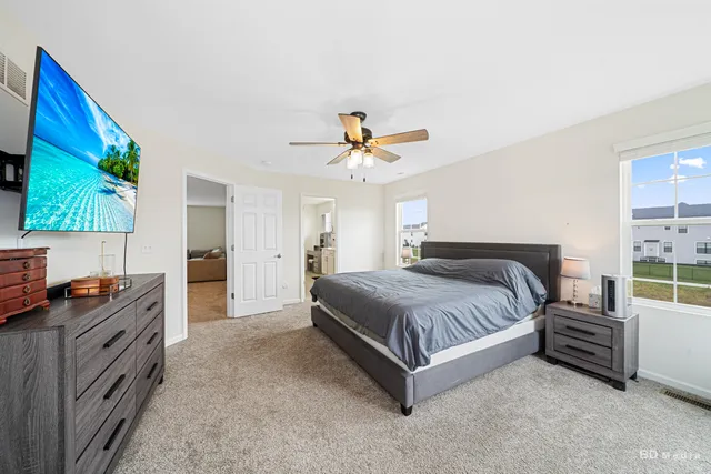 a spacious bedroom with a bed and a flat screen tv