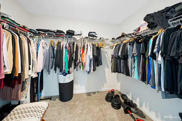 a view of walk in closet with clothes and shoes