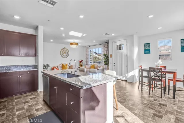 a kitchen with stainless steel appliances granite countertop a stove a sink a dining table and chairs