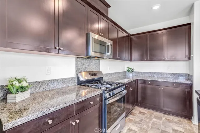 a kitchen with stainless steel appliances granite countertop a sink stove and cabinets