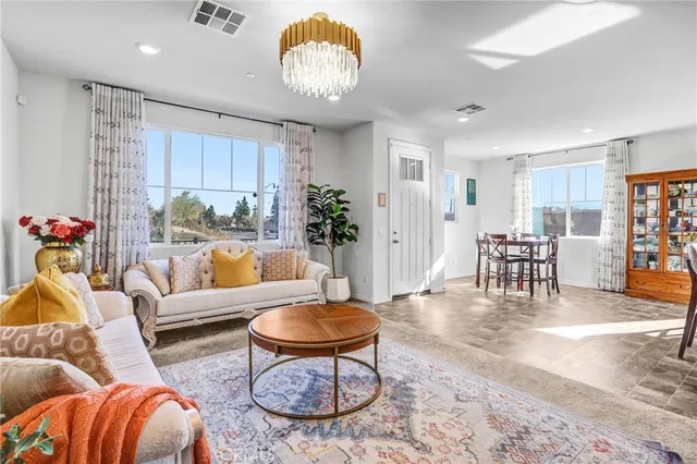 a living room with furniture a dining table and a chandelier