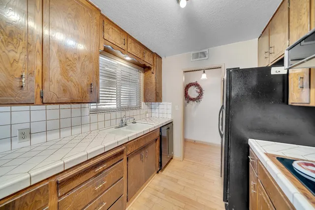 a kitchen with stainless steel appliances granite countertop a refrigerator and a sink