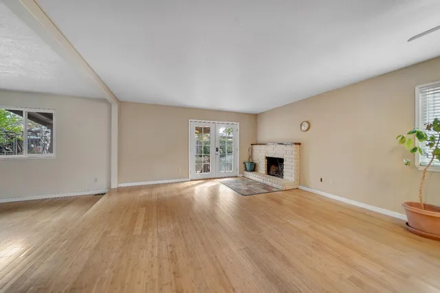 a view of empty room with wooden floor and fireplace