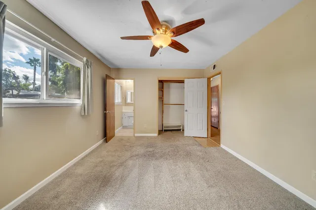an empty room with closet and windows