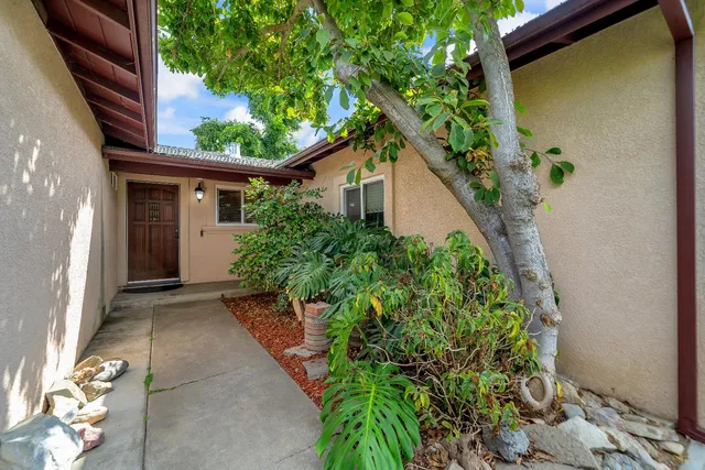 a yellow house with a flower garden in front of it