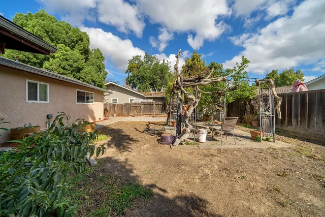a view of a house with backyard and sitting area
