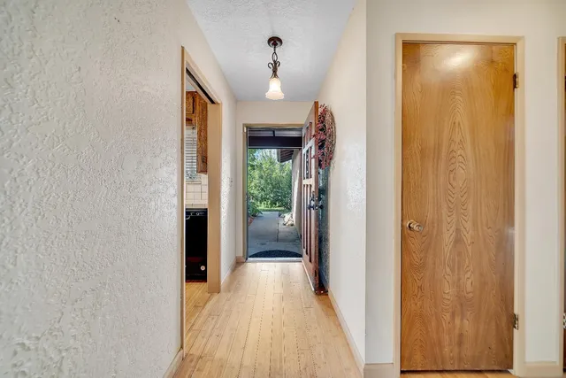 a view of a hallway with wooden floor and entryway