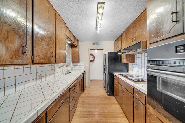 a kitchen with stainless steel appliances granite countertop a sink and cabinets