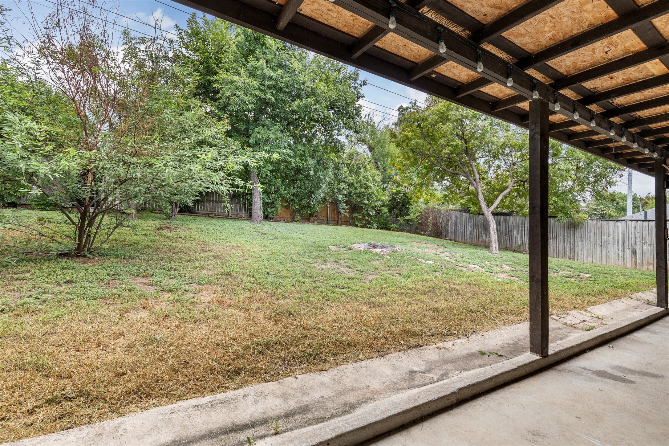 7506 Glenhill Road Austin, TX 78752 - Photo 20 of 24 A backyard with mature trees provides ample room for outdoor activities, all beneath a sheltering covered patio.