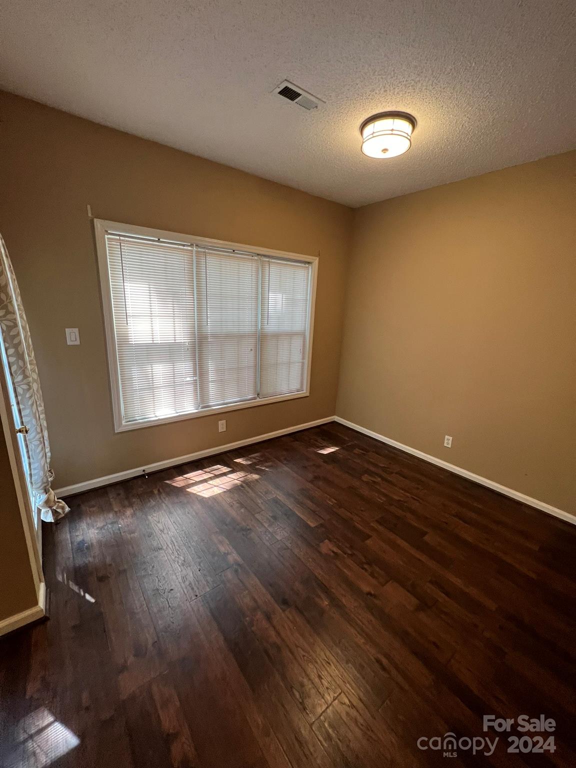 4124 Beaufain Street Raleigh, NC 27604 - Photo 9 of 12 an empty room with wooden floor and windows
