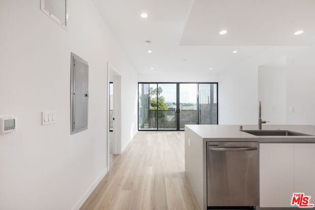 a view of a kitchen with a sink and wooden floor